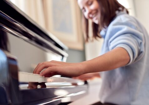 Close,Up,Of,Smiling,Teenage,Girl,At,Home,Playing,The